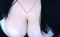 Buxom brunette shows off her cleavage and sucks a dildo on